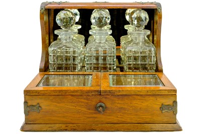 Lot 180 - A late Victorian oak tantalus and cigar cabinet.