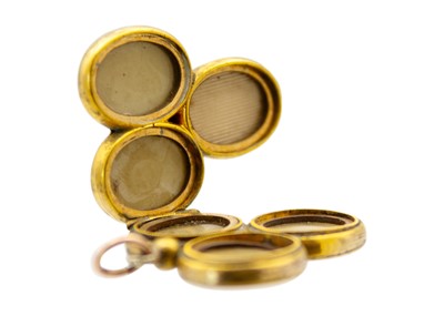 Lot 1 - A Victorian gold front and back foliate engraved triform locket pendant.