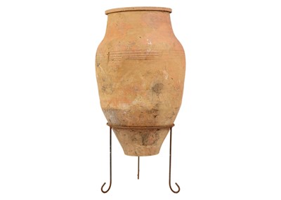 Lot 118 - A terracotta olive jar on metal stand.