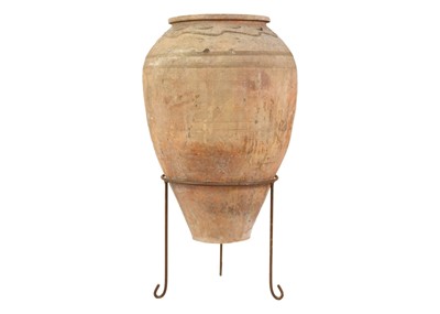 Lot 117 - A terracotta olive jar on metal stand.