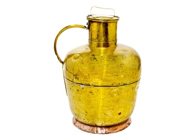 Lot 1063 - A large brass and copper milk jug and cover.