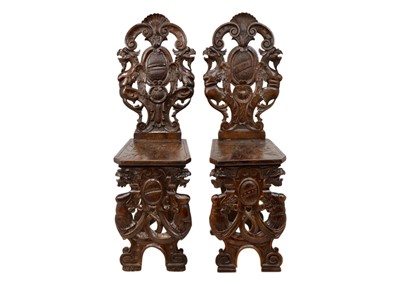 Lot 1048 - A pair of Italian walnut sgabello chairs.