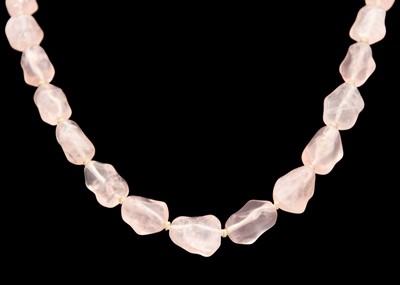 Lot 19 - A Chinese rose quartz irregular bead necklace with silver gilt filigree clasp.