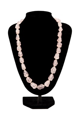 Lot 19 - A Chinese rose quartz irregular bead necklace with silver gilt filigree clasp.