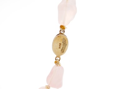 Lot 19 - A Chinese rose quartz irregular bead necklace with silver gilt filigree clasp.