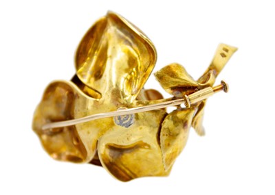 Lot 33 - An 18ct burnished gold rose design brooch set with three brilliant cut diamonds.