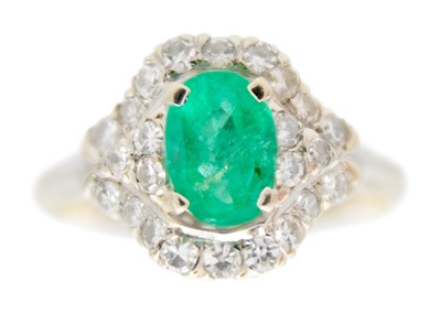 Lot 86 - An 18ct white gold emerald and diamond cluster ring.