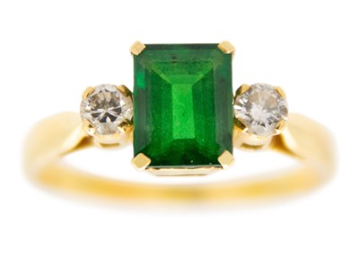 Lot 69 - An 18ct synthetic emerald and diamond set three-stone ring.