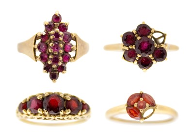 Lot 180 - A selection of four 9ct garnet set dress rings.