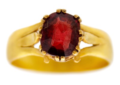 Lot 131 - A Victorian 22ct band ring, later applied with an oval cut garnet.