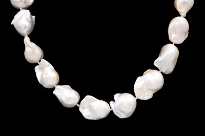 Lot 236 - A strand of Baroque ivory pearls with 14ct ball clasp.