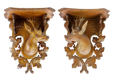 Lot 75 - A pair of Black Forest linden wood wall brackets.