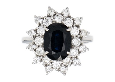 Lot 210 - An 18ct white gold, 3.00ct blue sapphire and diamond cluster ring.