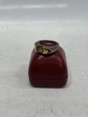 Lot 5 - A silver and gold peridot ring, size O/P.