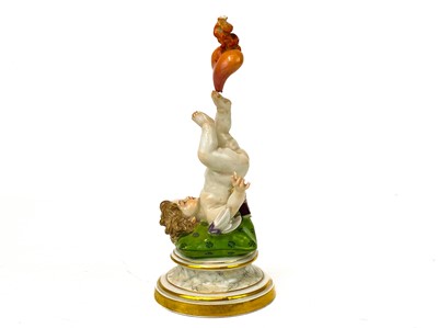 Lot 776 - A Meissen figure of Cupid balancing a flaming heart on his foot.