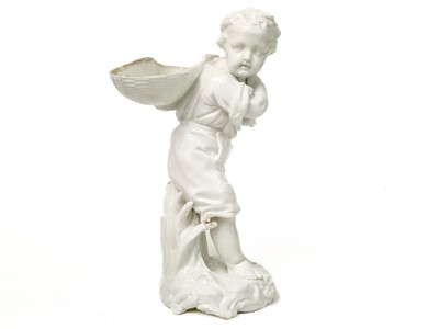 Lot 777 - A Dresden white glazed figure of a boy with a basket.