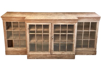 Lot 979 - A Georgian style glazed pine breakfront low bookcase.