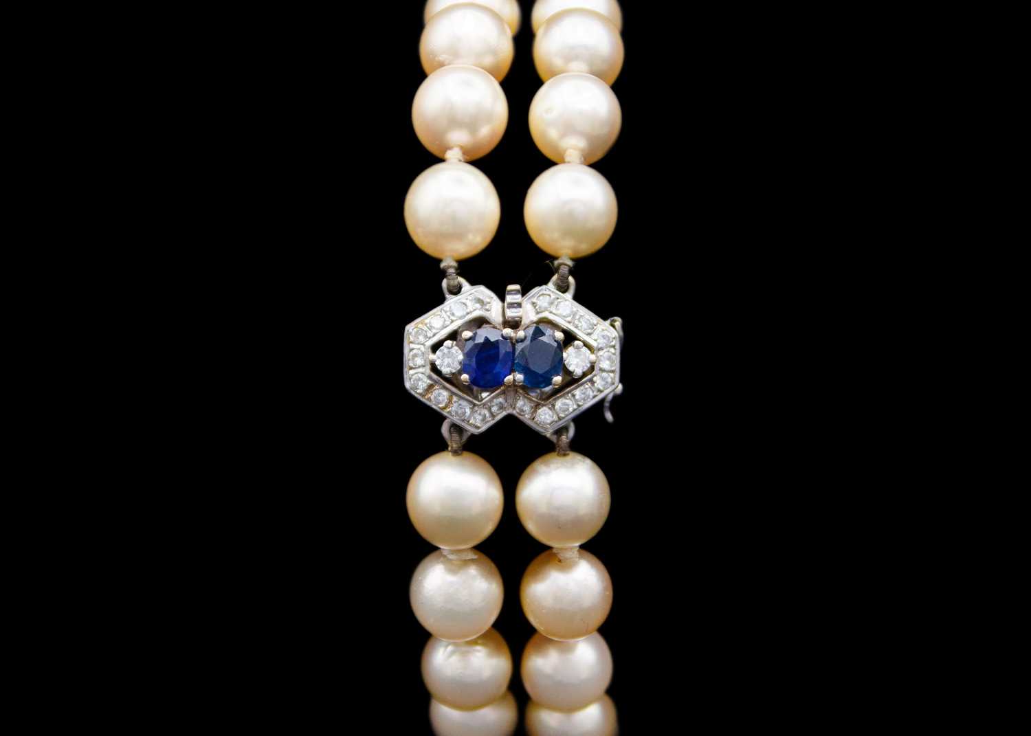 Lot 209 - A double row cultured pearl bracelet with 18ct diamond and sapphire set clasp.