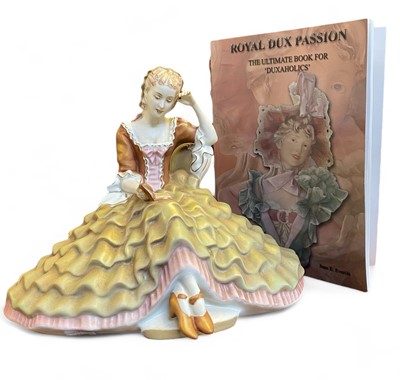 Lot 571 - A Royal Dux porcelain figure of a Lady reading a book.