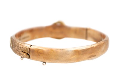 Lot 63 - An early 20th century 9ct rose gold hinged buckle bangle.