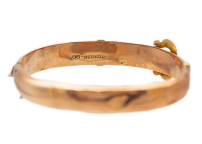 Lot 63 - An early 20th century 9ct rose gold hinged buckle bangle.