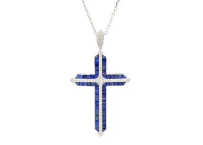 Lot 124 - A stylish 18ct white gold diamond and sapphire set cross pendant necklace.