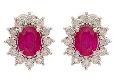 Lot 130 - A good pair of 18ct white gold oval ruby and diamond set cluster stud earrings.