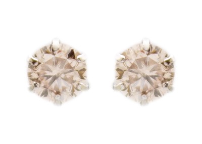 Lot 137 - A platinum pair of diamond solitaire stud earrings.