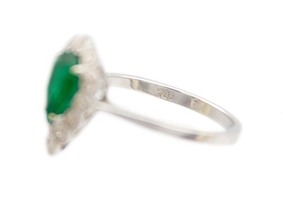 Lot 147 - An attractive 18ct white gold pear cut emerald and diamond set ring.