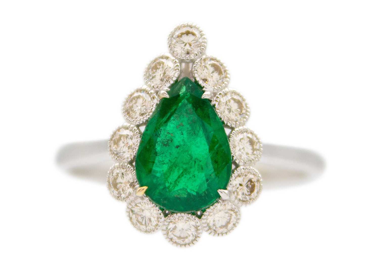 Lot 147 - An attractive 18ct white gold pear cut emerald and diamond set ring.