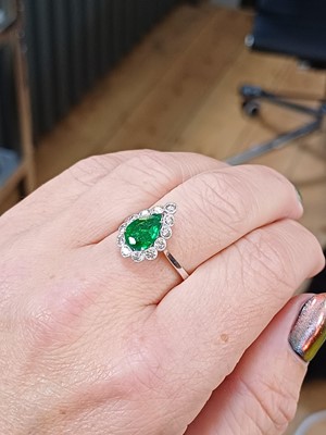 Lot 147 - An attractive 18ct white gold pear cut emerald and diamond set ring.