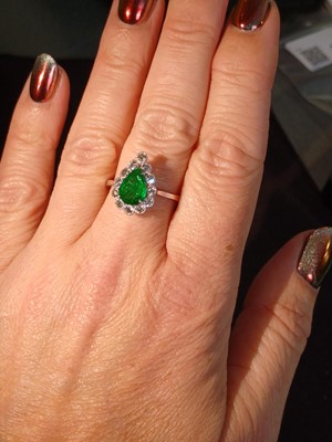 Lot 147 - An attractive 18ct white gold pear cut emerald and diamond set ring.