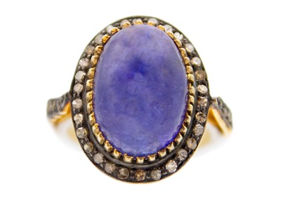 Lot 218 - A silver gilt dress ring set with a large cabochon tanzanite and rose cut diamonds.