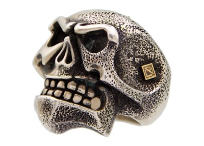 Lot 176 - CHRIS BLACK DESIGNS - A contemporary heavy silver and 18ct skull ring.