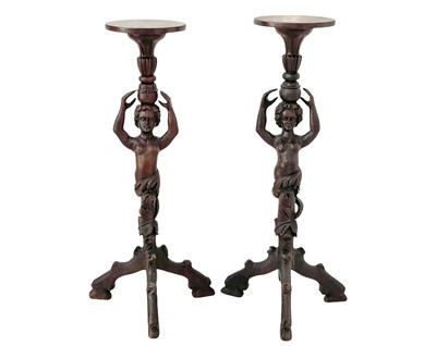 Lot 1005 - A pair of carved walnut torcheres or candle stands.