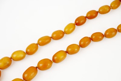 Lot 293 - A string of graduated oval butterscotch amber beads.