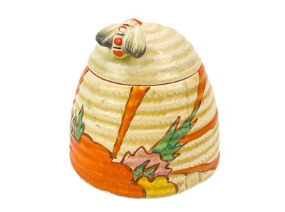 Lot 613 - A Clarice Cliff Fruit Burst pattern bee hive honey pot and cover.