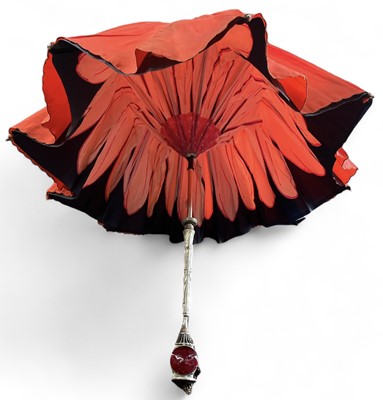 Lot 29 - A white metal and silk parasol with a flower...