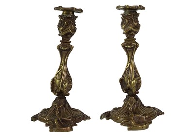 Lot 18 - A pair of French rococo style bronze candlesticks.