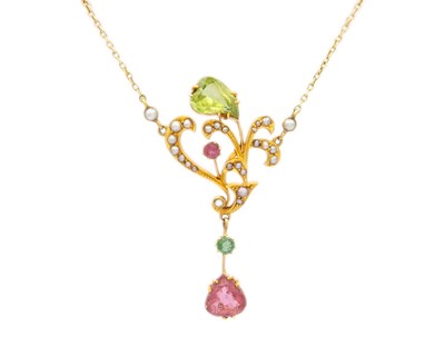 Lot 10 - An Edwardian 15ct Art Nouveau peridot, pink tourmaline and split pearl set pendant necklace.