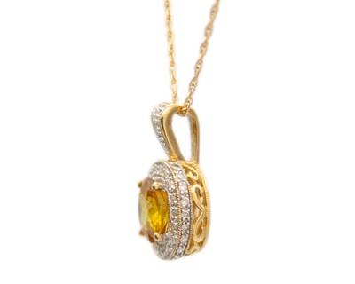 Lot 16 - A 9ct yellow sphene (titanite) and diamond cluster pendant on a 9ct necklace.