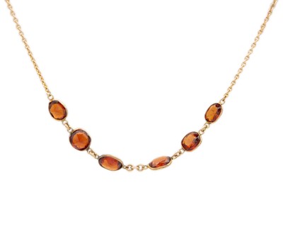 Lot 25 - A 9ct gold (tested) hessonite garnet set necklace.