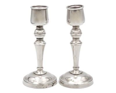 Lot 83 - A pair of George V silver weighted candlesticks.