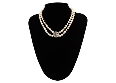 Lot 106 - An early 20th century double-strand white pearl necklace with 18ct white gold diamond set clasp.