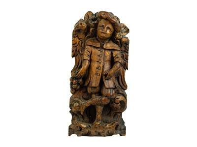 Lot 1187 - A Flemish carved oak plaque of a boy with grapes.