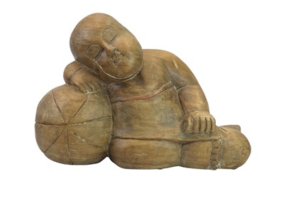 Lot 14 - A large wood carved sleeping Buddha with a ball.