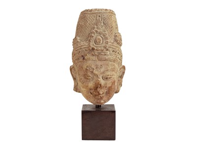 Lot 1058 - An Indian red sandstone head of a deity.