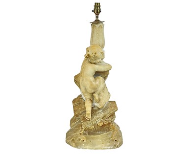 Lot 573 - A large alabaster figural lamp of a boy climbing a cliff.