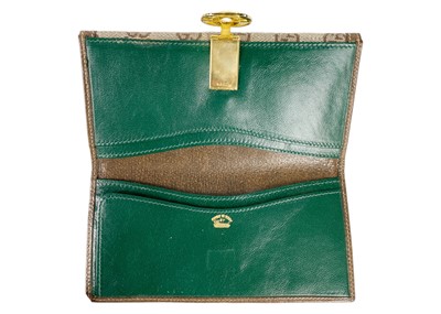 Lot 322 - GUCCI - A wallet in embroidered GG fabric and brown leather trim.