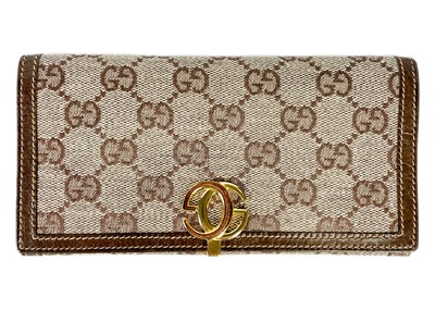 Lot 322 - GUCCI - A wallet in embroidered GG fabric and brown leather trim.